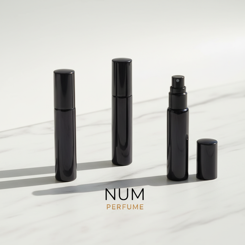 Tres decants de perfume de nicho NUM sobre mármol blanco